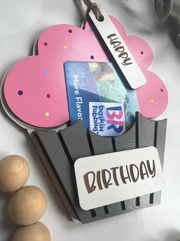 Gift card holder with 'Happy Birthday' tag and decorative elements on a light background