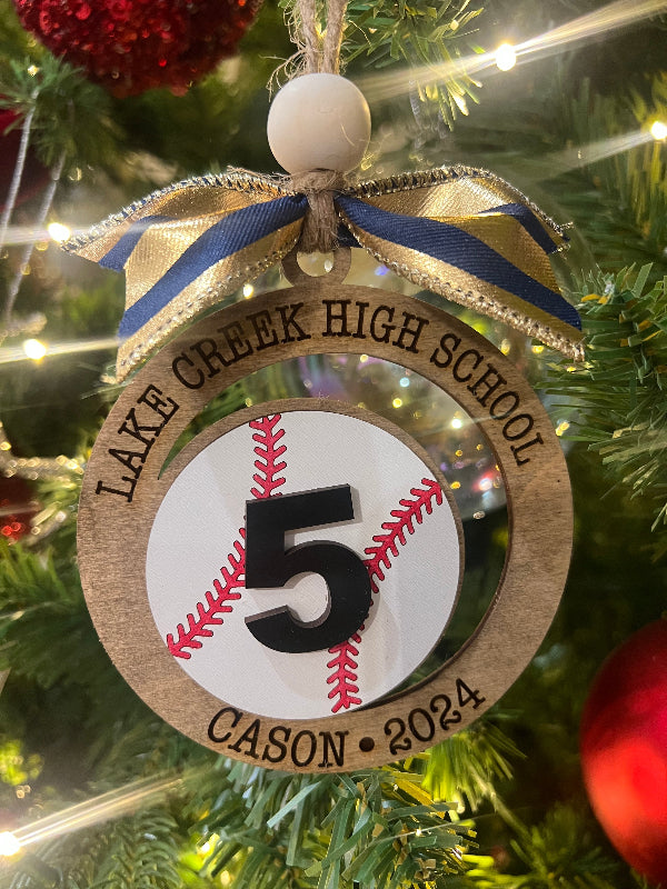 Christmas ornament with 'Lake Creek High School' and number '5' on a baseball design, hanging on a tree.