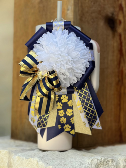 Decorative mini mum with white flowers, gold and navy ribbons on a mannequin head.