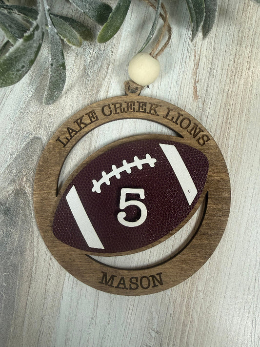 Football ornament on laser cut wood with team name, player name and jersey number.