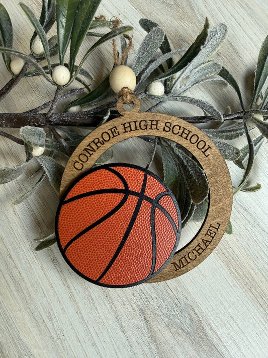 Decorative ornament with basketball design and 'Conroe High School' text, placed on a branch.
