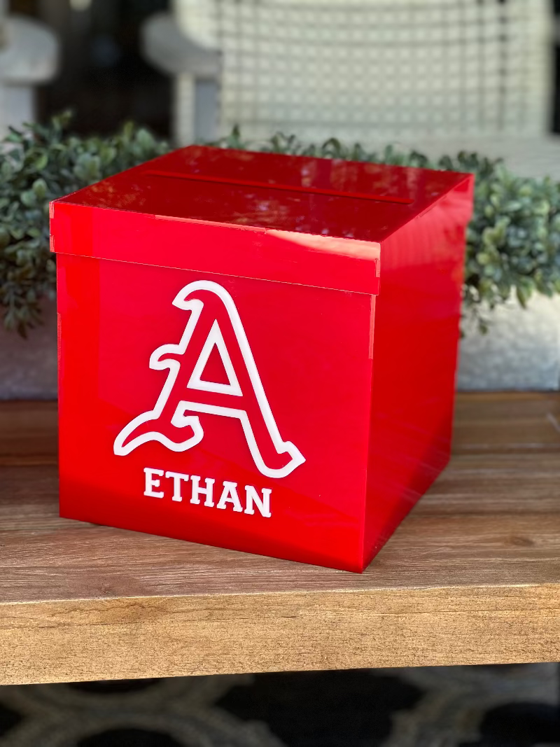 Red box with a white letter 'A' and name 'Ethan' on a wooden surface.