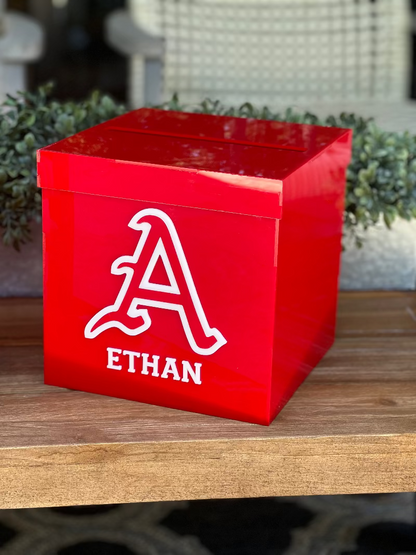 Red box with a white letter 'A' and name 'Ethan' on a wooden surface.