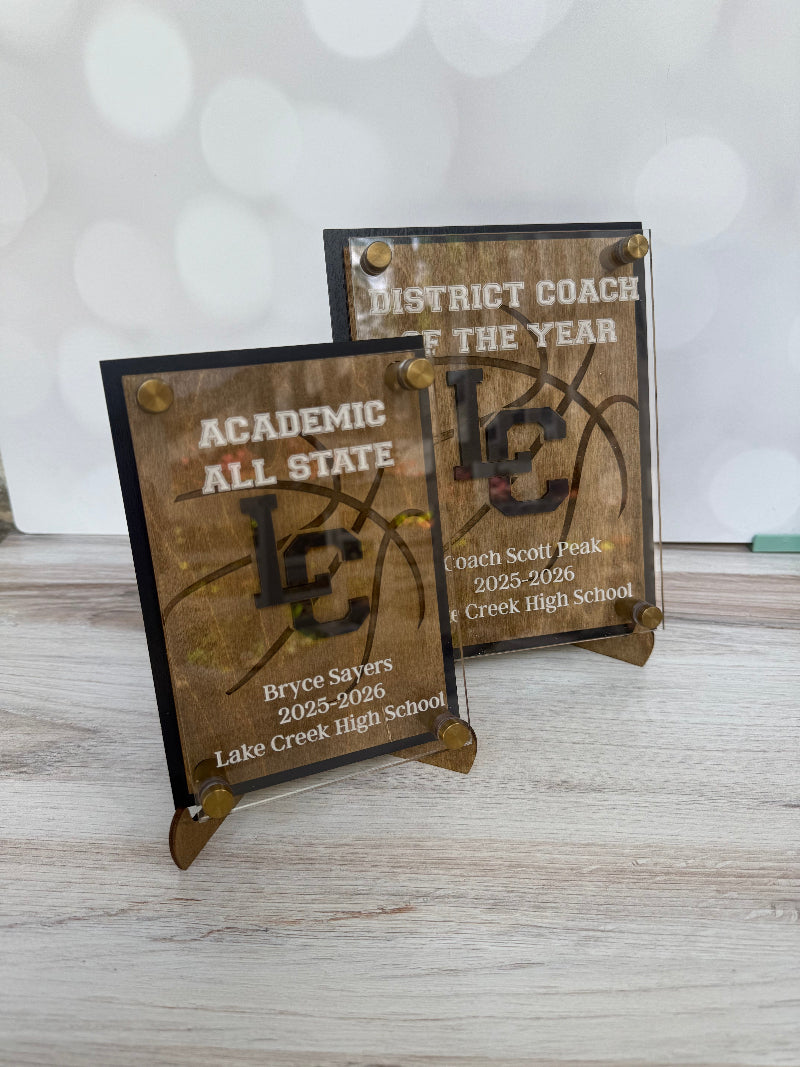 Two wooden plaques with engraved text on a light gray surface.