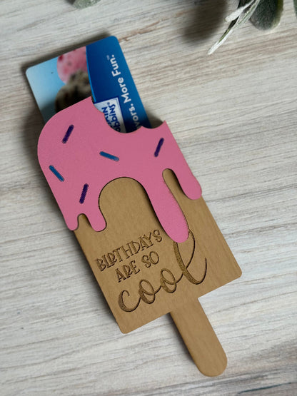 Ice cream popsicle-shaped laser-cut gift card holder with pink top and 'Birthdays are so cool' text on a wooden surface.