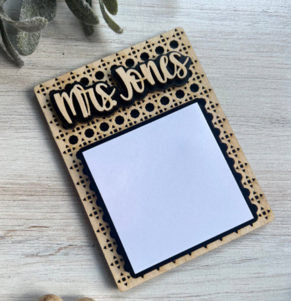 Personalized wooden sticky note holder with 'Mrs Jones' engraving on a light wooden surface.