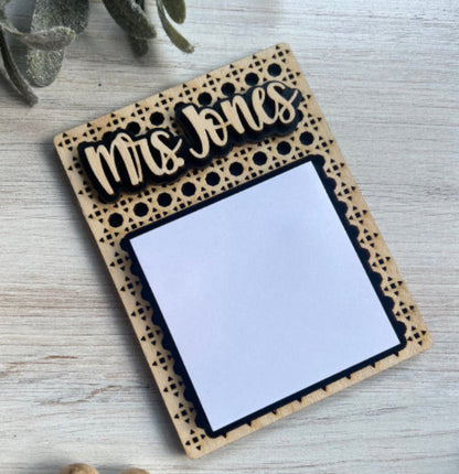 Personalized wooden sticky note holder with 'Mrs Jones' engraving on a light wooden surface.