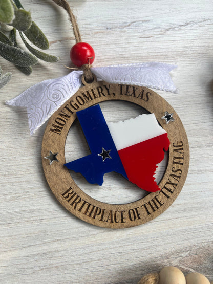 Decorative ornament with Texas flag design and 'Montgomery, Texas' text on a wooden circle.