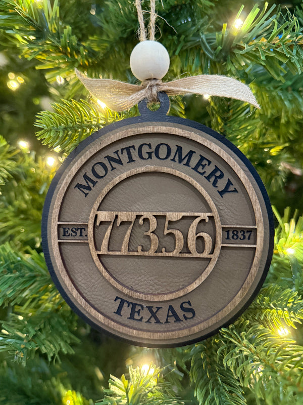 Ornament with 'Montgomery 77356 Texas' on a Christmas tree.