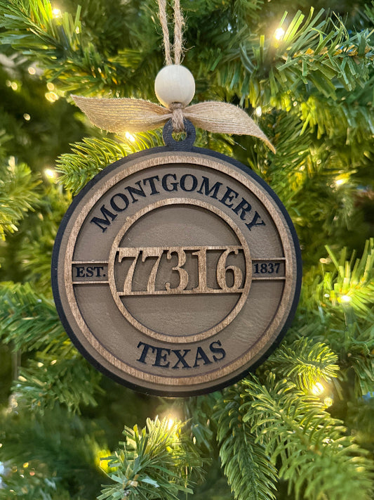 Decorative ornament with 'Montgomery 77316 Texas' on a Christmas tree.